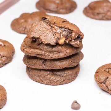 Chocolate Rolo Cookies stacked on top of each other on a baking sheet.