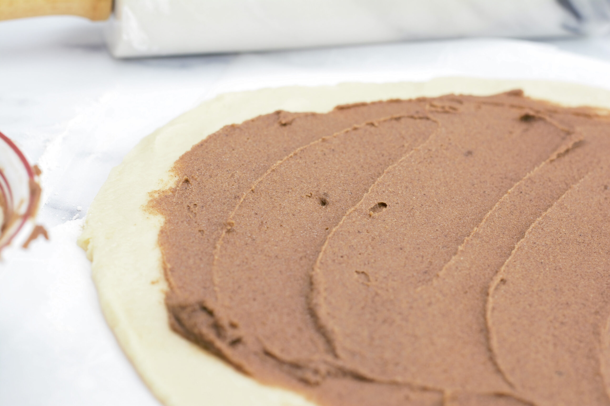 Dough rolled out on countertop with cinnamon filling.