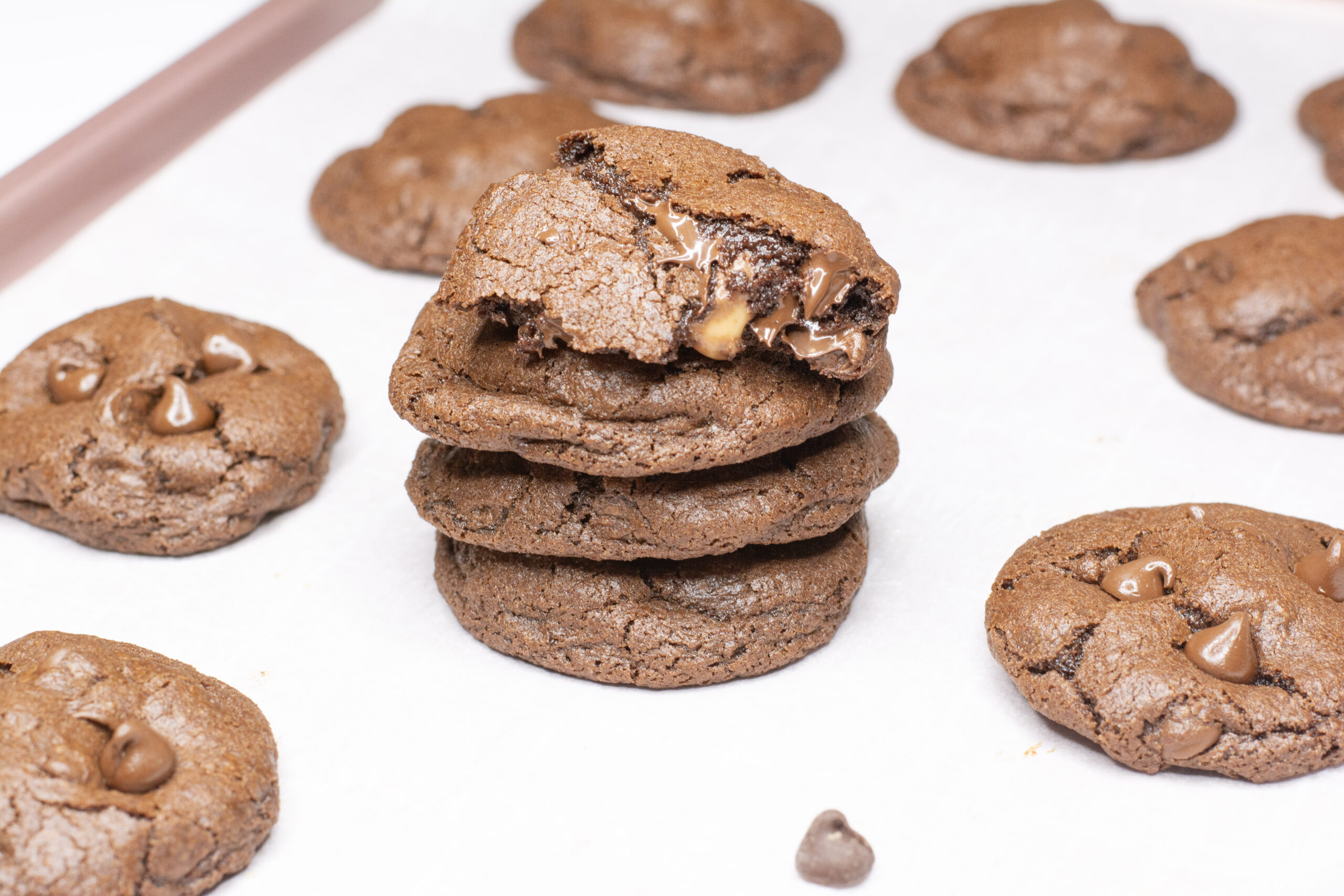 Chocolate Rolo Cookies on a baking sheet with four of the cookies stacked on top of each other.