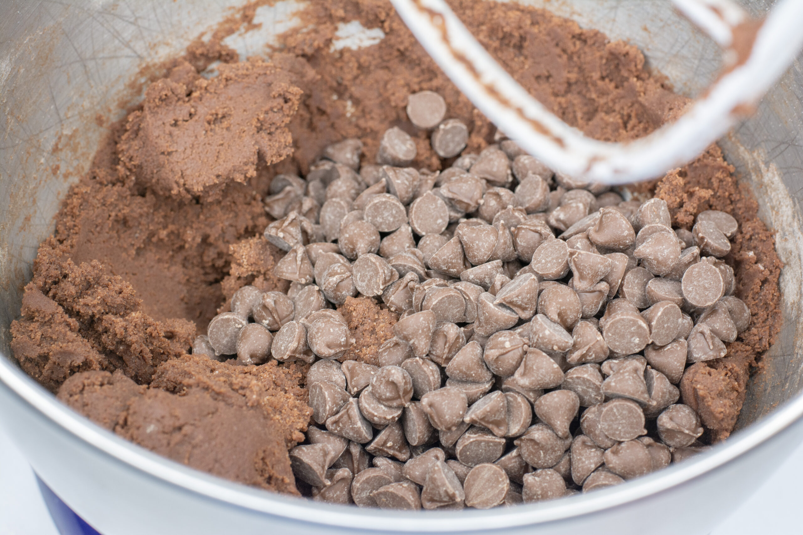 Chocolate Chips added to bowl with cookie dough.