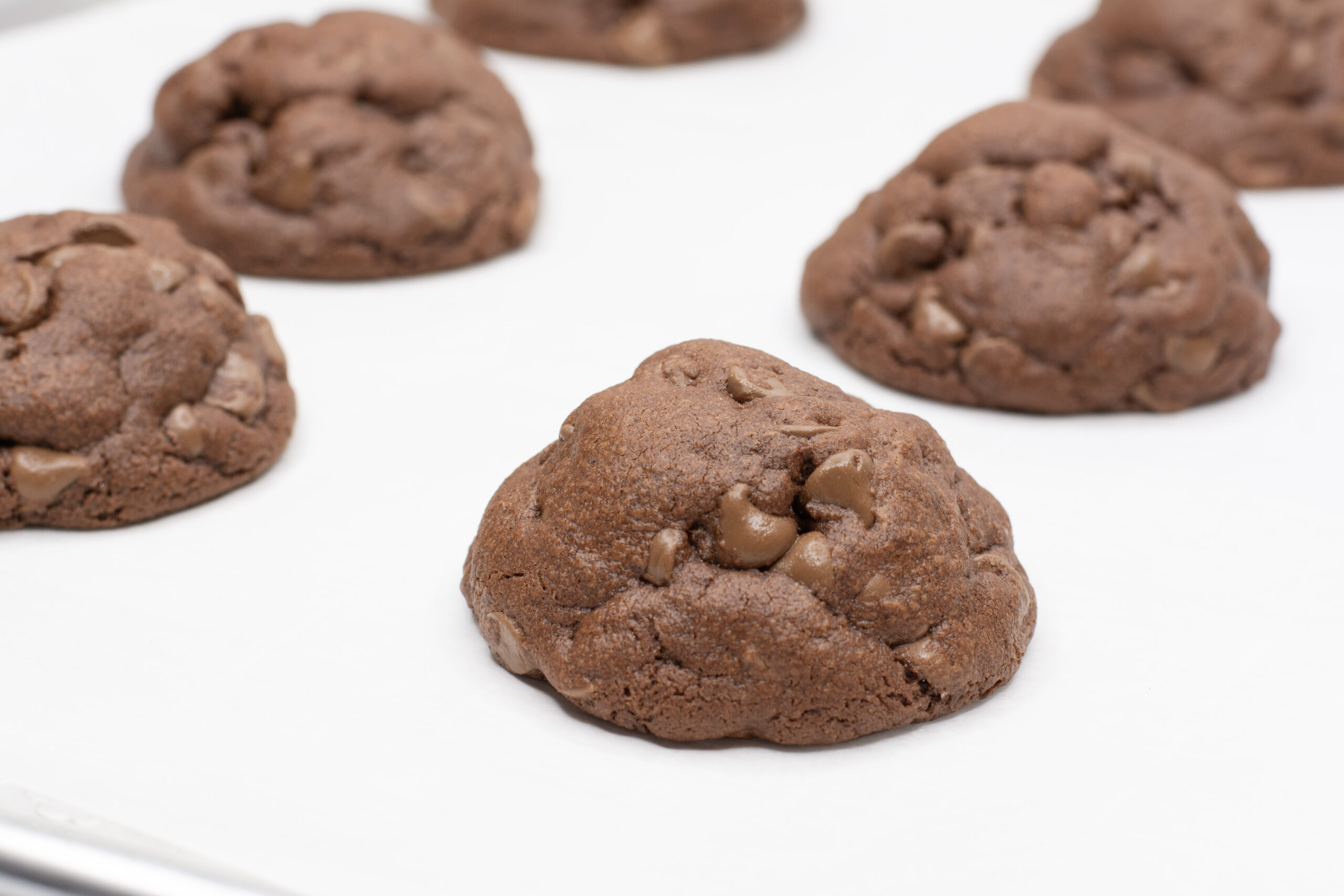 Chocolate pudding cookies baked and out of the oven on a pan.