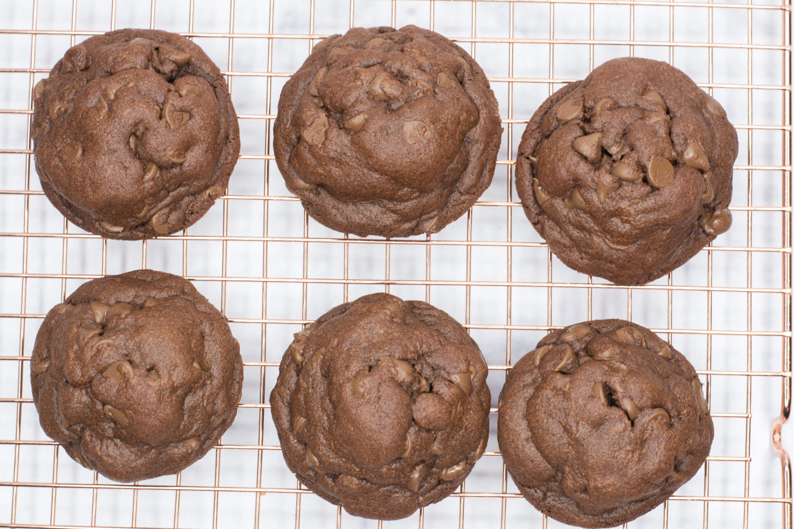 6 chocolate pudding cookies on a wire cooling rack.