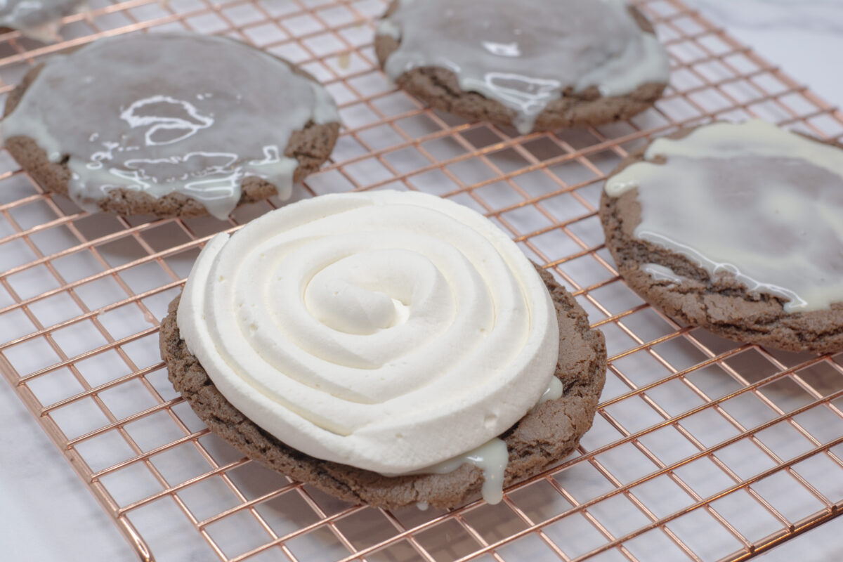 Whipped cream on top of a chocolate cookie with sweetened condensed milk.