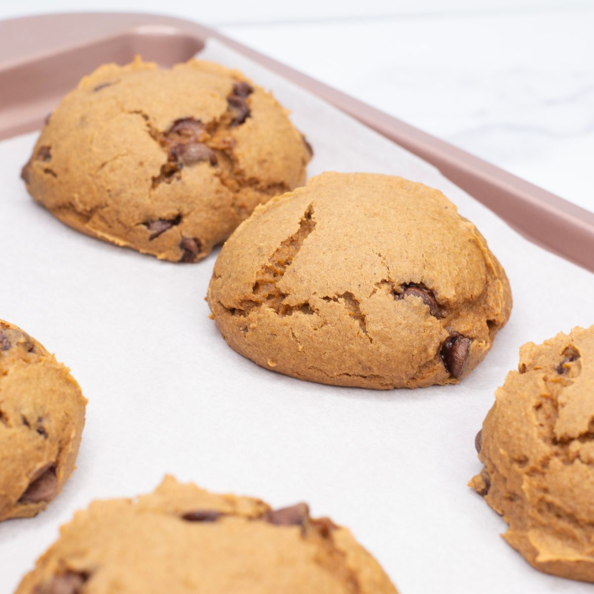 pumpkin cookies on a cookie sheet.