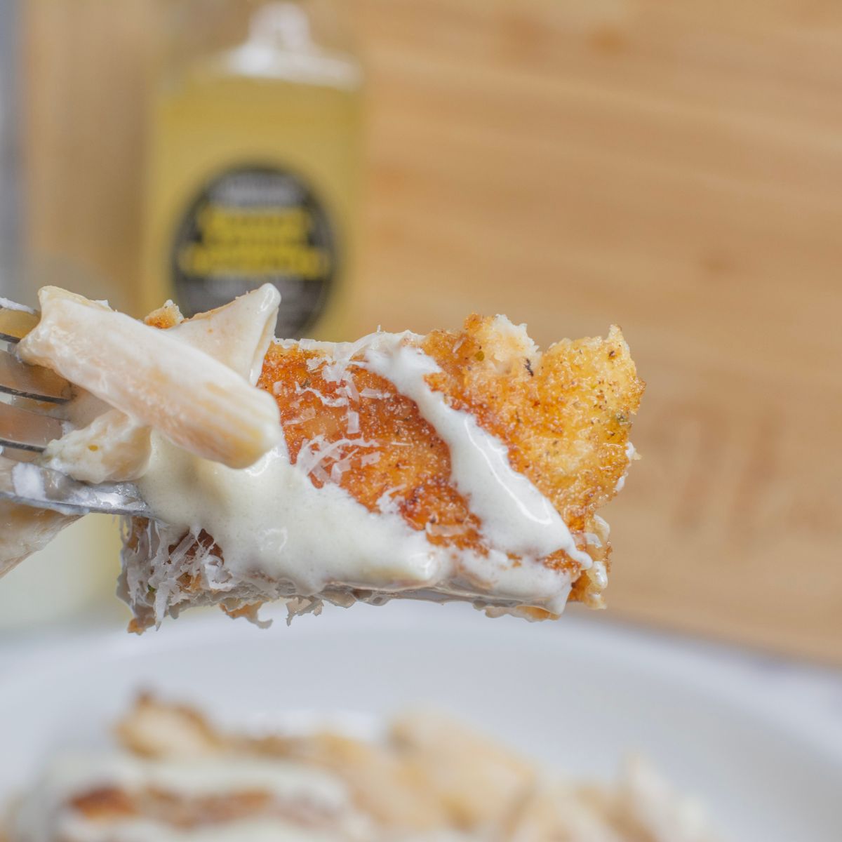 Bite of breaded chicken with lemon sauce on it.