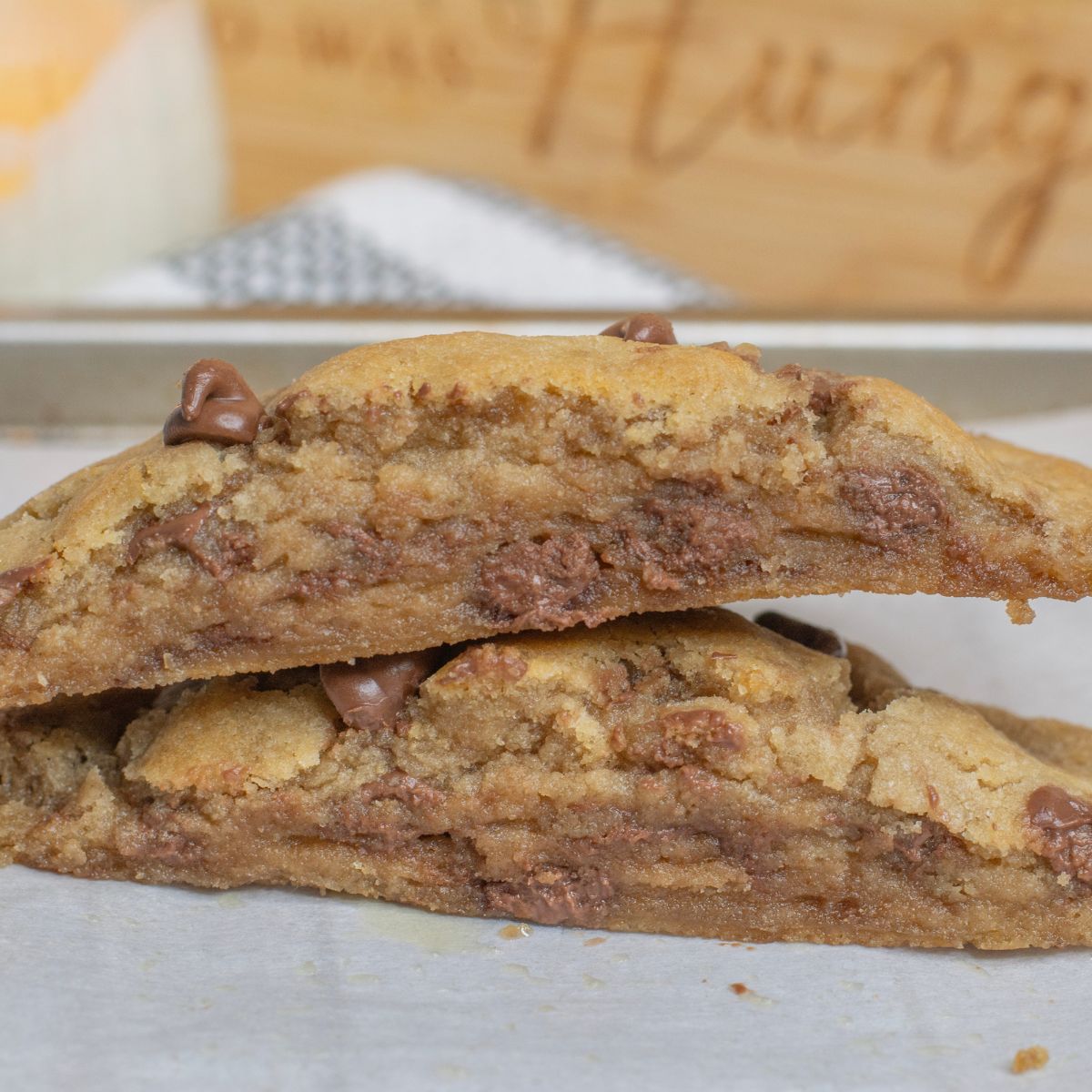 One large single serve chocolate chip cookie sliced in half with gooey chocolate in the middle of the cookie