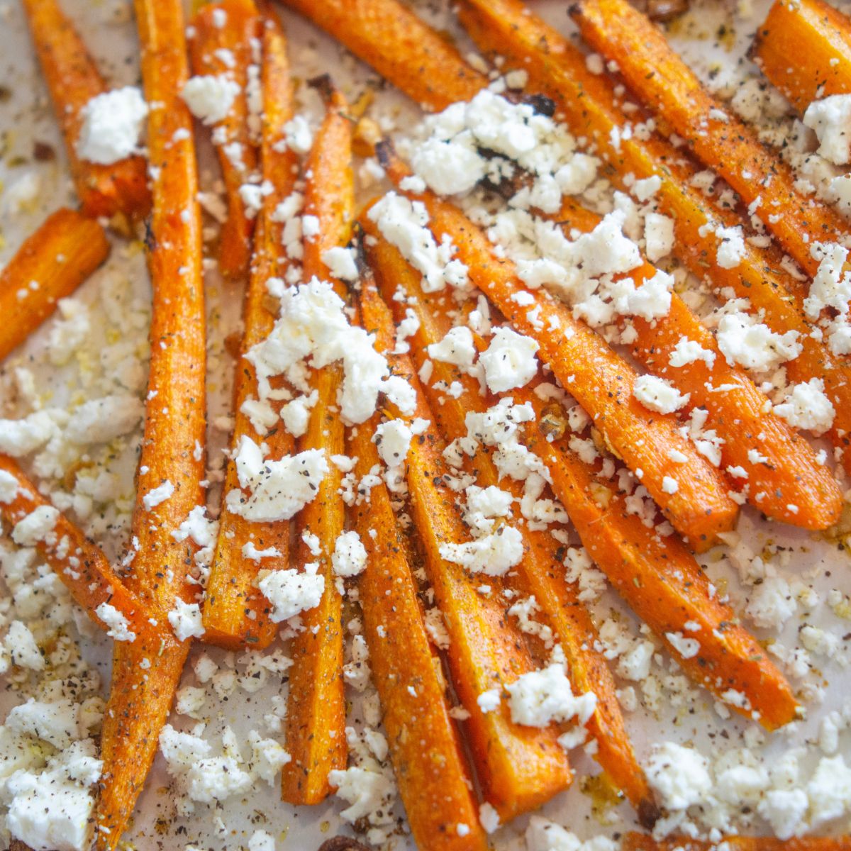 Feta crumbled on top of a bed of roasted carrots.