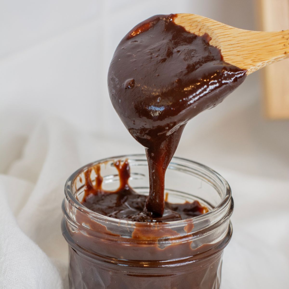 hot and silky homemade hot fudge running off of a spoon
