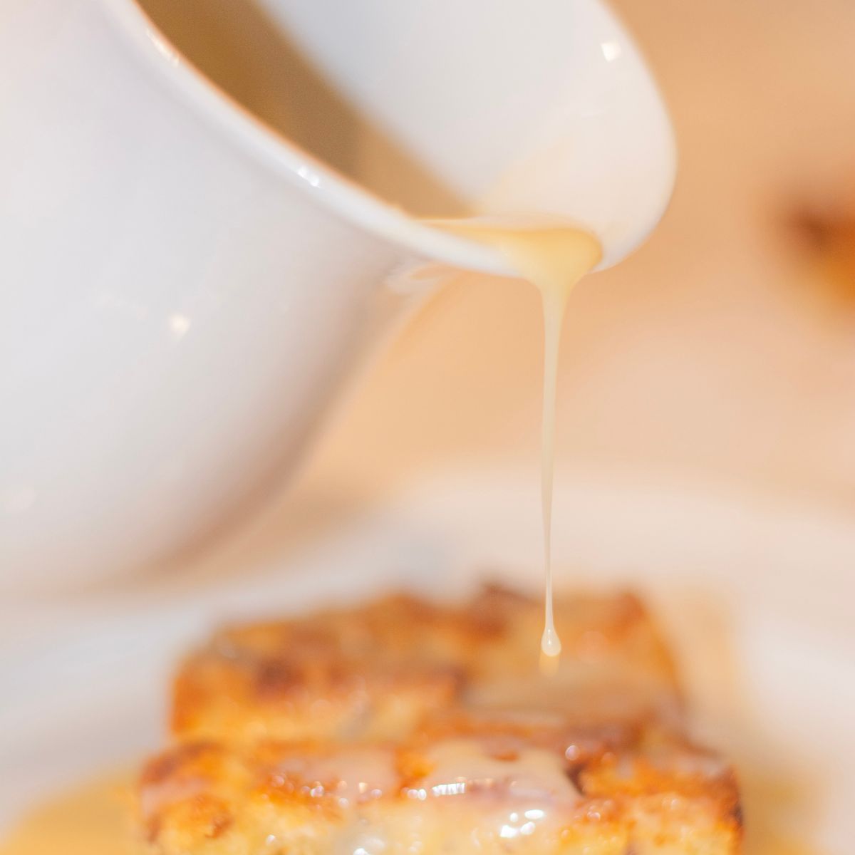close up shot of the caramel sauce pouring over cinnamon bread.