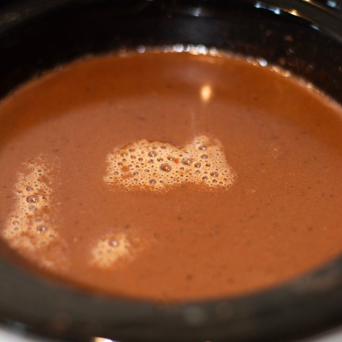 Hot chocolate with bubbles and foamy in a crock pot.