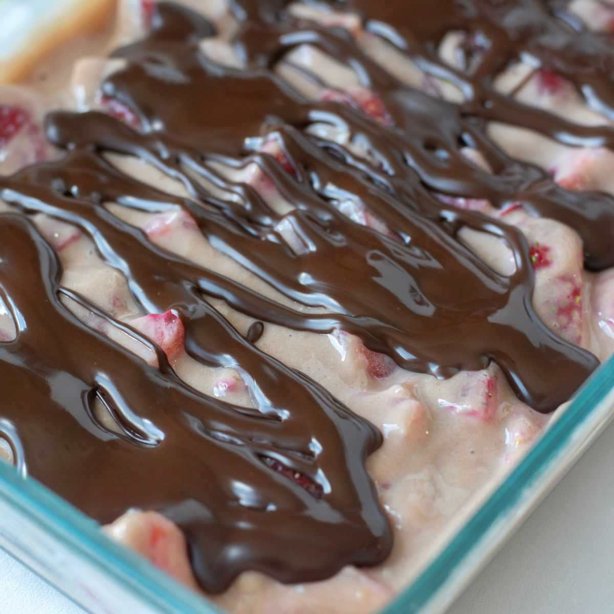 dark chocolate drizzled over the top of a strawberry and greek yogurt combination.