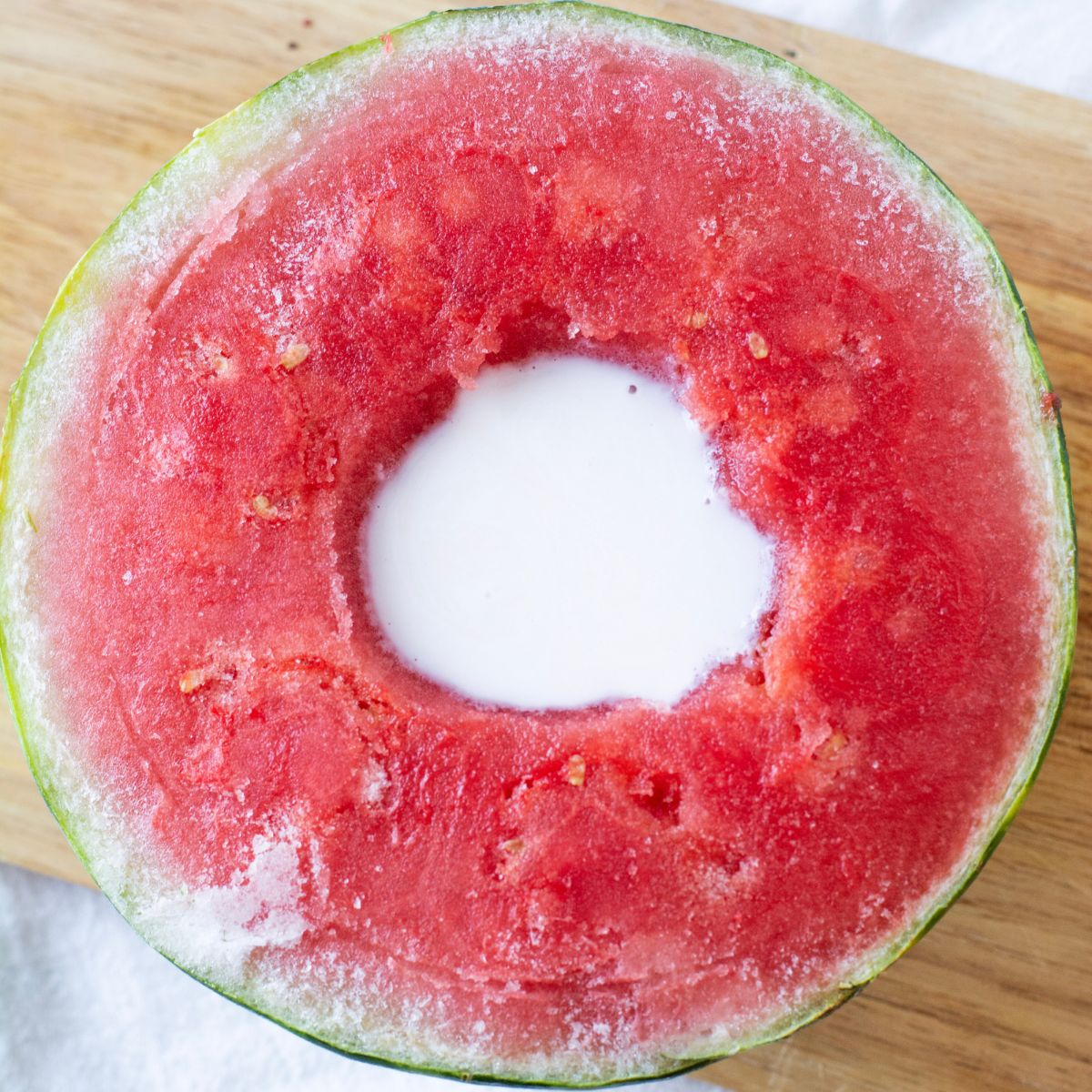 Coconut creamer poured into well of the watermelon.