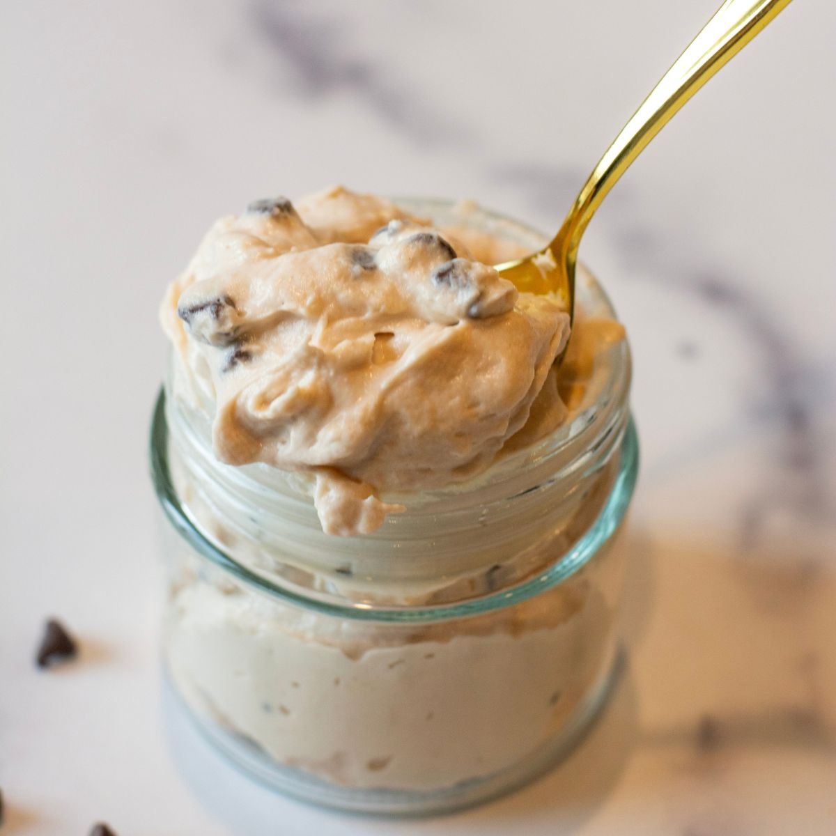 Chocolate protein cheesecake yogurt fluff in a bowl with a spoon.