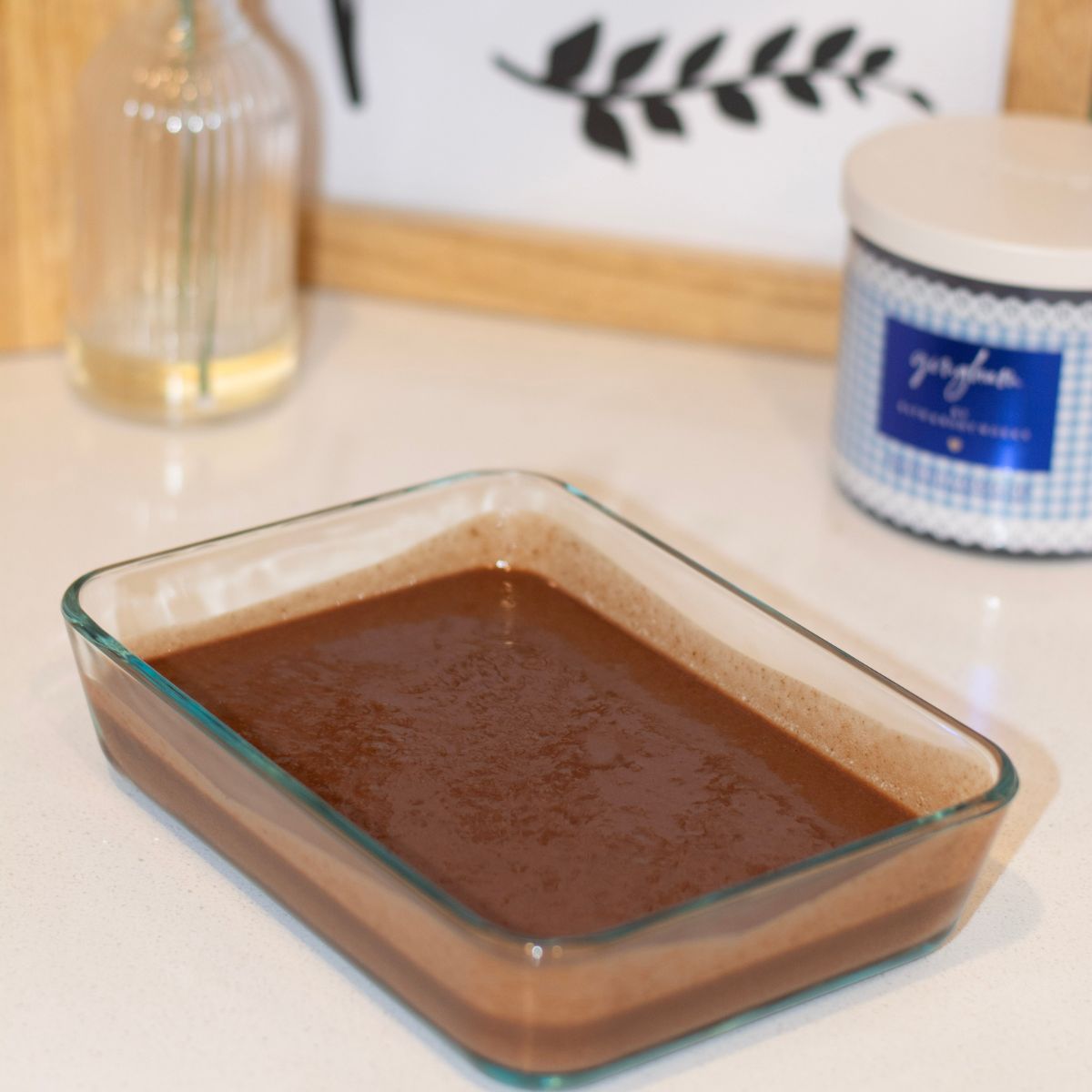 Chocolate protein chia pudding in a glass container on the countertop.