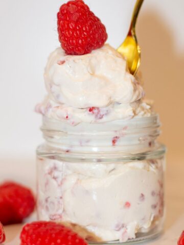 Raspberry cheesecake protein jello in a bowl with a spoon.
